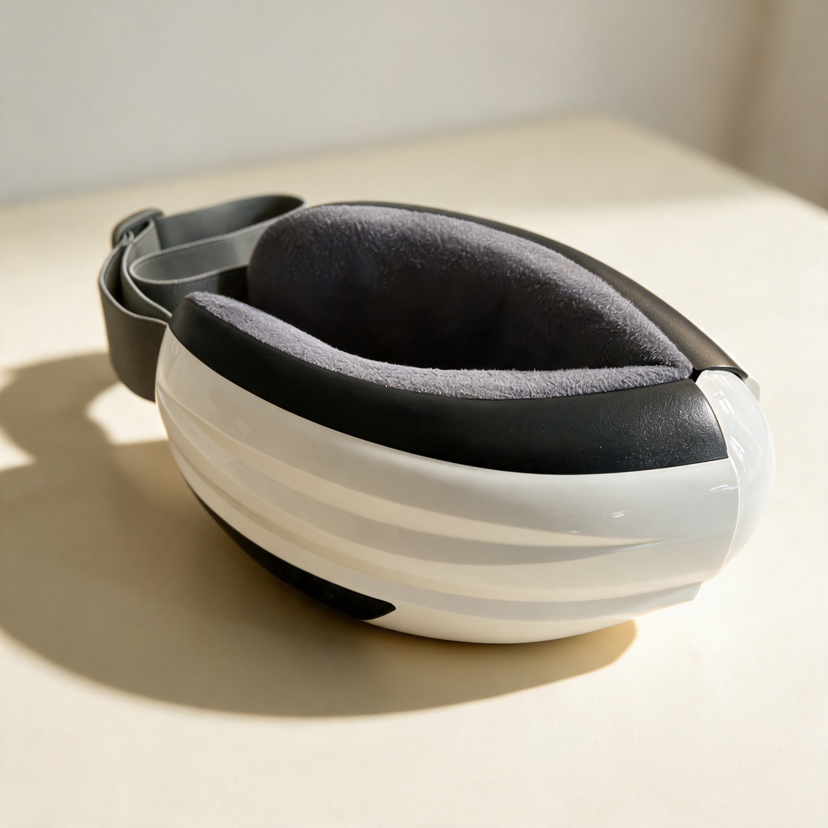 The Heated Eye Massager folded shut with its adjustable strap