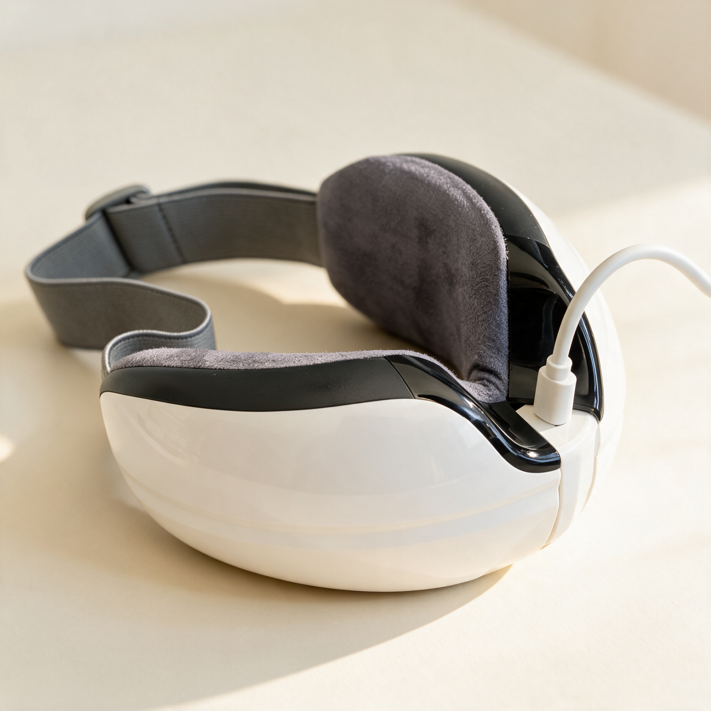The Heated Eye Massager upside down with the micro-USB cable plugged in to charge